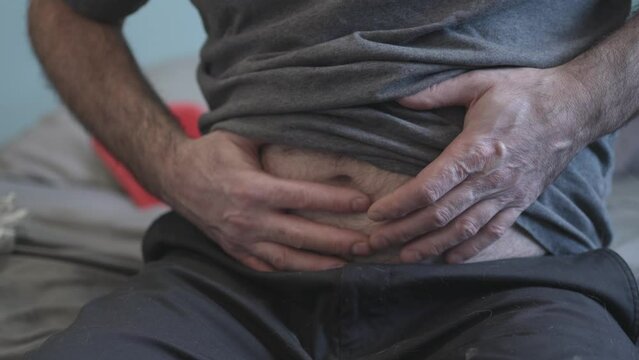 Man With Stomach Pain Giving Himself Abdominal Self Massage