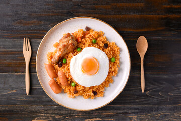 Fried rice with chicken, sausage and fried egg on wooden background, Table top view
