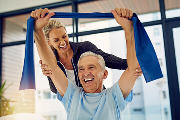 Helping him achieve great progress. Shot of a physiotherapist helping a senior patient stretch with...