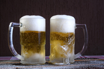 delicious mug of super cold and refreshing draft beer on the table in the blurred background