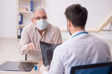 Obraz premium Old male patient visiting young male doctor radiologist during p