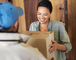 It's finally arrived. Shot of a smiling young woman standing at her front door receiving a package...