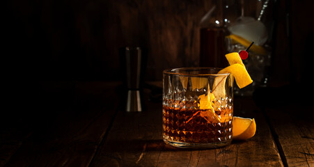 Sazerac cocktail with cognac, bourbon, absinthe, bitters, sugar and lemon zest. Old wooden bar...