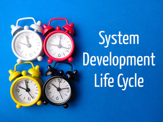 Top view clock with text System Development Life Cycle on blue background.