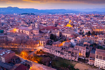 Fototapeta na wymiar View from drone of Spanish town of Vic with tiled roofs of old buildings and ancient cathedral in winter evening, Barcelona province, Catalonia