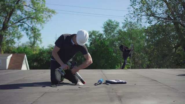 Roofing Inspector performing a core test on a flat roof on a sunny day