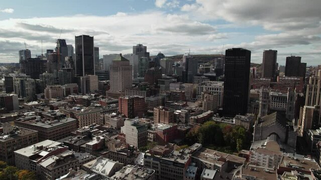 Drone flies over old Montreal toward the business district of montreal. Mont Royal in the background.