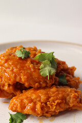 spicy buffalo wing on a plate served gourmet decorated with coriander leaves