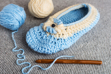 wooden crochet hook close-up. Needlework and wool in balls in the background.