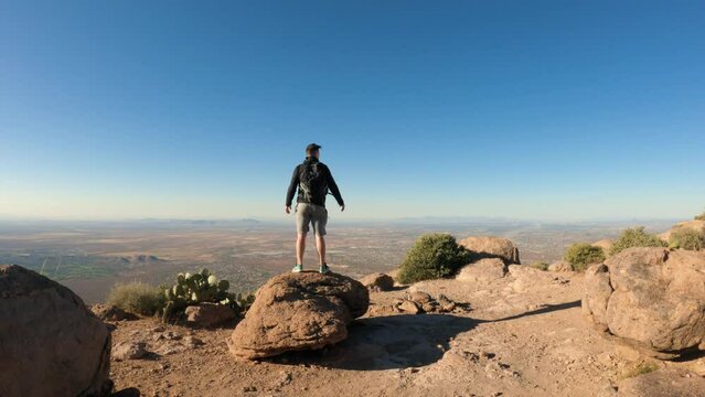 Hiker Holding Arms Out with Astonishing Mountain Top View of Southwest America