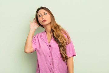 asian woman looking serious and curious, listening, trying to hear a secret conversation or gossip,...