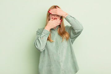 redhead pretty woman covering face with both hands saying no to the camera! refusing pictures or...