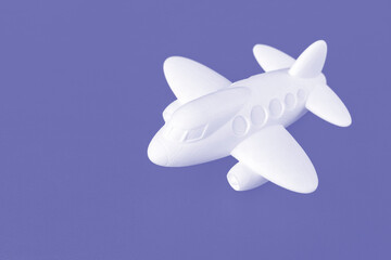 Toy plane on a purple background with space for text. the concept of air transport, tourism, travel. copy space. view from above