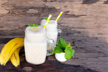 Banana fresh cocktail vanilla smoothies  fruit juice beverage healthy the taste yummy in glass drink episode good morning on wooden background from the top view.