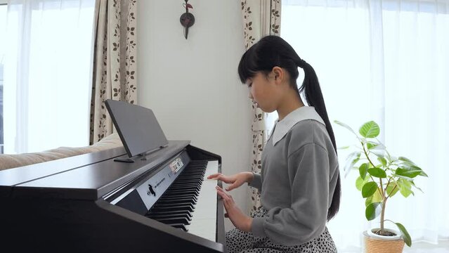 ピアノの練習をする小学生の女の子