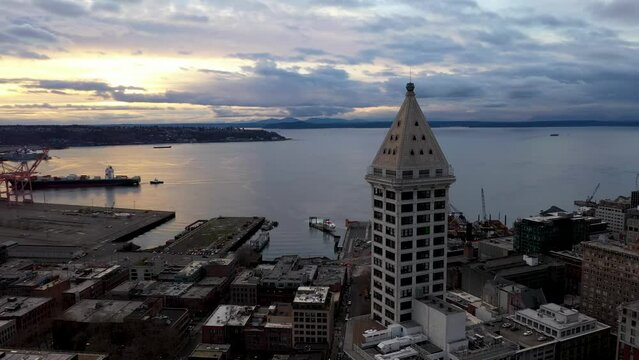 Aerial of Seattle's Smith Tower overlooking the sun setting over the Puget Sound.