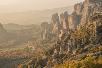Looking across the rock formations in Meteora with monastery in the distance at dusk, Greece
