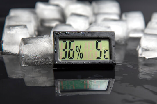 digital thermometer for measuring air temperature and humidity against the background of frozen ice