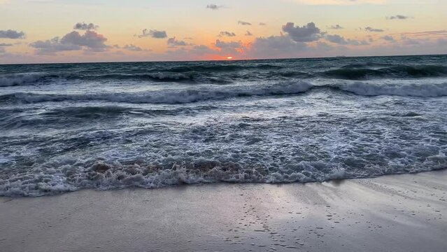 Sunrise over the sea and beach with beautiful landscape in Riviera Maya, Mexico. Sun above the water in the early morning over the Caribbean sea with gentle waves hitting the sand.
