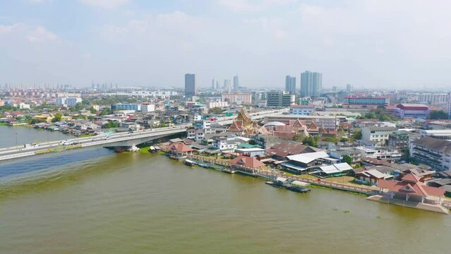 Aerial top view of residential local houses with Phasi Charoen, Chao Phraya canal or river, nature trees, Nonthaburi City, Thailand in urban city town in Asia, buildings.