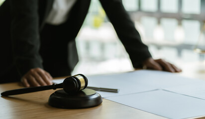 Legal law, advice and justice concept, counselor lawyer or notary working on a documents and report of the important case and wooden gavel, brass scale on table in courtroom.