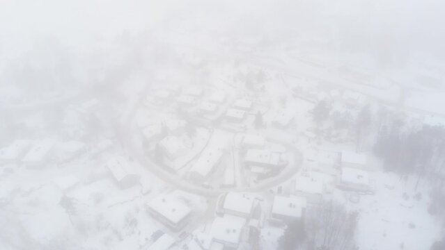 Winter Landscape With Village Buildings Covered  With Thick Fog And Mist - aerial drone shot