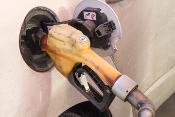 Gasoline pump refilling the automobile gasoline tank. Gasoline prices increasing. Petrol prices concept. Expensive petrol prices concept. Gas station background. Filling gasoline to the car