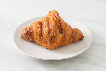 fresh croissant on white plate