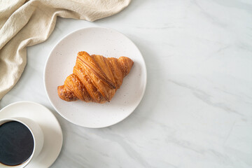 fresh croissant on white plate