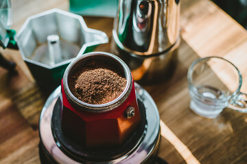 Finely ground coffee and vintage coffee maker moka pot on wooden table at home ,Selective focus.