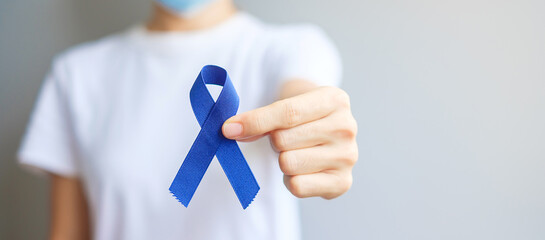 March Colorectal Cancer Awareness month, Woman holding dark Blue Ribbon for supporting people...