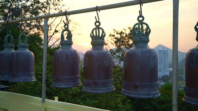 metallic bells hanging in a row outside in thai buddhist temple, Thai temple bell which believe that who knock this bell will get the good luck