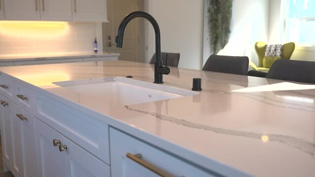 White Granite Island Top with a Modern Faucet in an Open Concept Home
