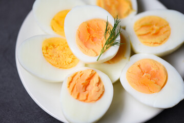 Eggs breakfast, fresh eggs menu food boiled eggs in a white plate decorated with leaves green dill background, cut in half egg yolks for cooking healthy eating