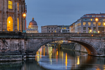View along the Museum Island in Berlin at dusk with the cupola of the rebuilt City Palace in the back