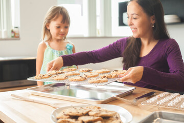 Mother and daughter baking cookies in a bright kitchen