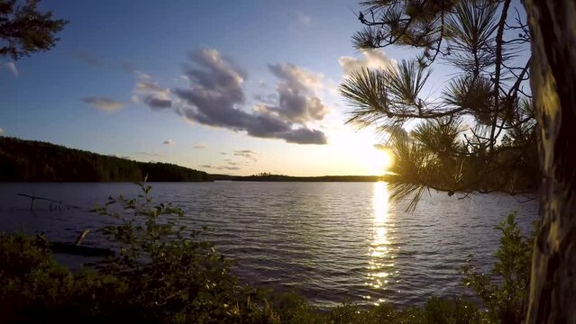 Sunset time lapse of wavy backcountry boreal shield lake in Northern Ontario Canada