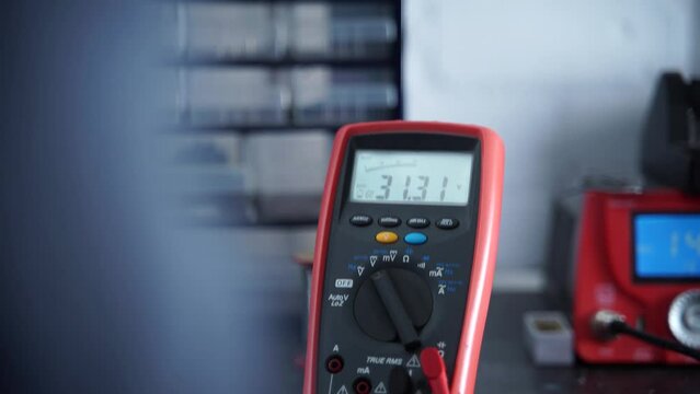 Electrical digital multimeter gets used to test electric currents. Young engineer test currents on a project.