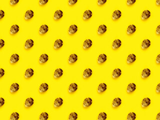 The easter background with the quail brown eggs pattern on the trendy yellow background.