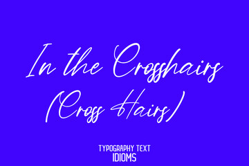 Naklejka na ściany i meble In the Crosshairs (Cross Hairs) Elegant Phrase Cursive Typographic Text idiom on Blue Background