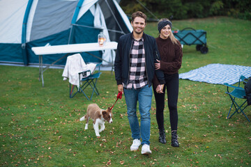 Fototapeta premium Young nice couple having fun on camping with dog