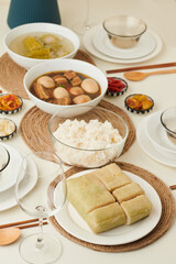 Dinner with delicious food cooked for Lunar New Year like braised pork with eggs, sticky rice cake...