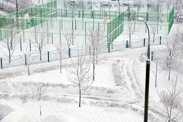 Sports ground covered with snow. Large snowdrifts on the playground in winter. Outdoor workout...