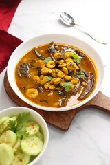 Tangy and spicy Shrimp curry. Tiny prawns curry made using dried mango and Indian spices. garnished with coriander and served with cucumber slices. Copy space.