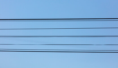 Electric wires against a blue sky.