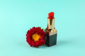 Red lipstick with red flower on blue background