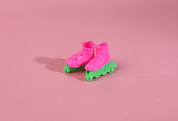 Doll roller skates on pink background. Minimal layout