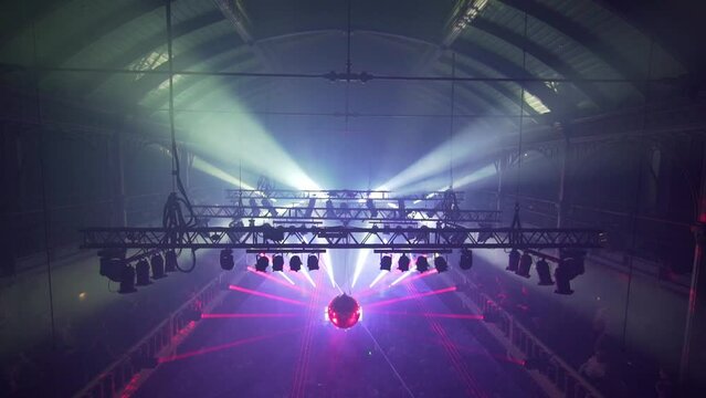 Light Show And Silhouette of audience crowd people enjoying dancing at club party. Nightclub DJ party people enjoy the music on the dancefloor - top view slow-motion