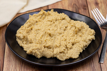 Hummus in a ceramic plate. Dishes of chickpeas, a vegetarian dish.