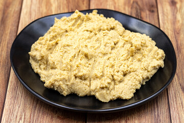 Hummus in a ceramic plate. Dishes of chickpeas, a vegetarian dish.